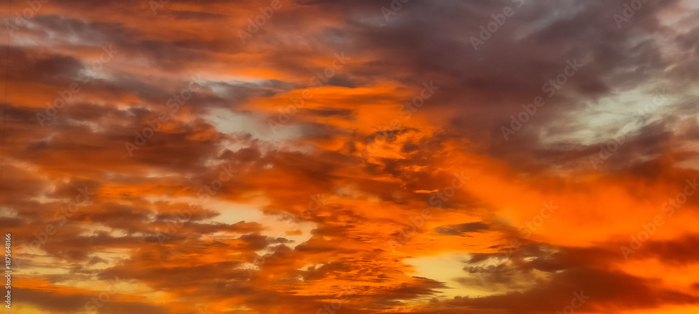 Fototapeta premium Cloudy sky at sunset in bright, warm colors, variegated colors for the background, rich clouds and sky