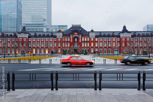 Wallpaper Mural The majestic historical building of Tokyo Train Station stands before modern office towers in gloomy morning light & cars pass by on the street before the pedestrian promenade in Chiyoda, Tokyo, Japan Torontodigital.ca