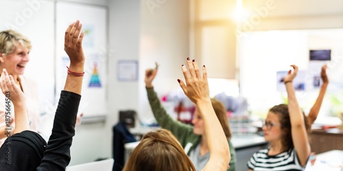 A diverse classroom with students raising hands, engaging in learning. Bright classroom, eager students, active participation, hands raised, education focus. Girls raising hands in classroom.