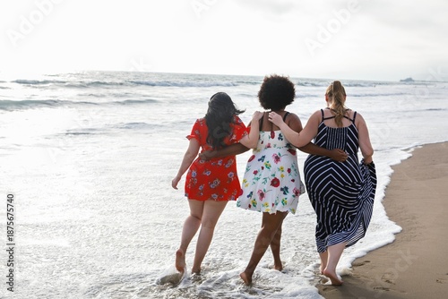 Photos Diverse women walking on a beach, enjoying the ocean waves