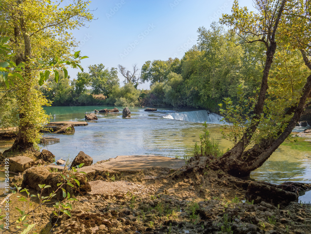 Fototapeta premium Scenic Turkish Getaway: Wide shot of Manavgat Waterfall near Side and Antalya, a peaceful natural landmark. Evoking Peace and Tranquility.