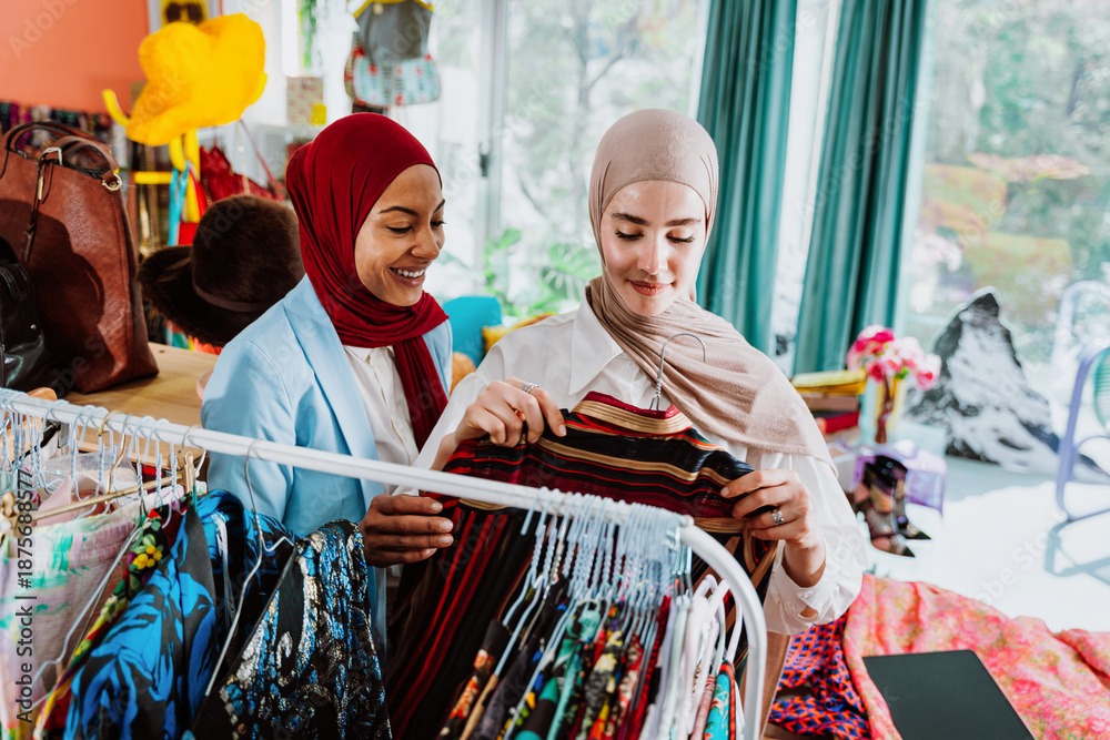 Fototapeta premium Modern diverse muslim women shopping clothing on digital tablet