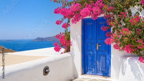 A classic Mediterranean scene featuring a vibrant blue door set against a pristine white stucco wall. Lush pink bougainvillea branches frame the doorway, with a breathtaking view of the turquoise sea 
