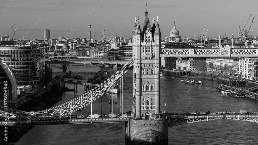Obraz premium Tower Bridge spanning the River Thames in black and white with London city skyline