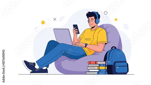 Young male student sitting comfortably on a bean bag chair while using his laptop and smartphone for studying at home.