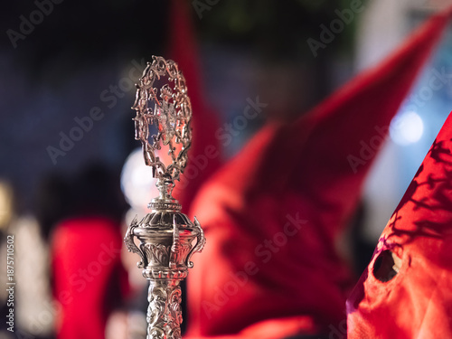 Bilde på lerret Close up of an ornate silver ceremonial staff in a night procession with red hoods
