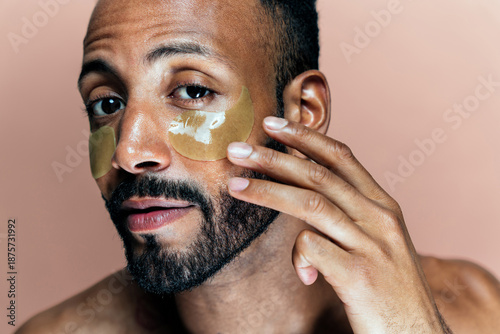 Foto Image of a young man taking care of his skin