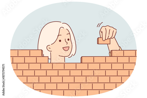 Woman builds brick wall by carefully stacking blocks, for concept of creating business structures