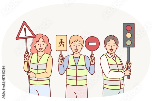 Traffic controllers urge young children to be careful while driving, holding road signs in hands