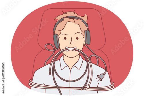 Man is tied up with computer wires and shows aggressive grimace caused by professional burnout