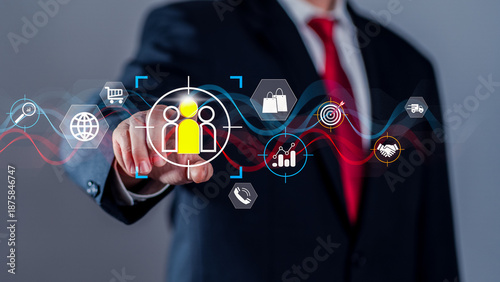 Businessman pointing at virtual target audience icon surrounded by marketing and sales symbols. Concept of customer segmentation, digital marketing strategy, CRM, lead generation, and business growth.