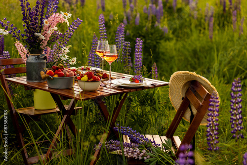 Obraz na plátne Simple countryside beautiful wedding decor, surprise romantic date outdoors, garden arrangement with lupins flowers on a meadow