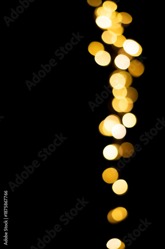 Golden blurred bokeh lights on black background. Christmas lights overlay.