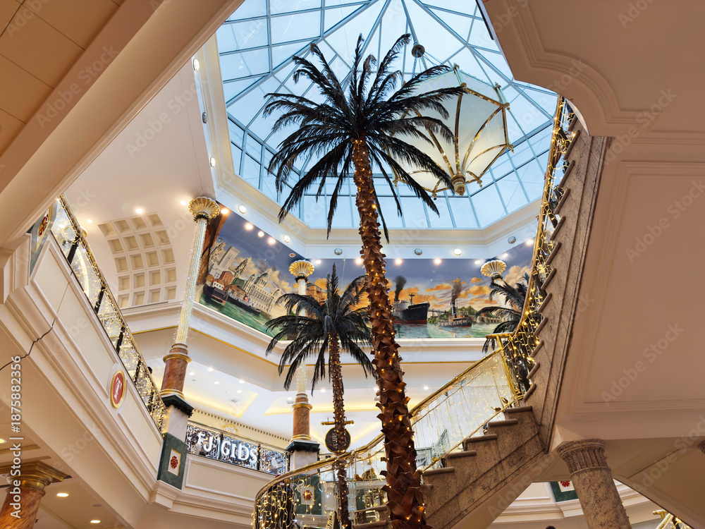 Fototapeta premium Indoor Trafford Centre atrium in Manchester mall with glass ceiling palm trees and festive lighting
