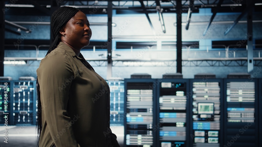 Fototapeta premium Technician in data center overseeing large scale IT gear to maintain seamless operations. IT professional walking in server hub, doing network management for increased uptime, camera A