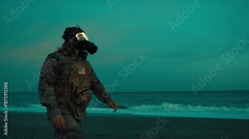 A patrol walk by an American soldier wearing a gas mask new the ocean at night