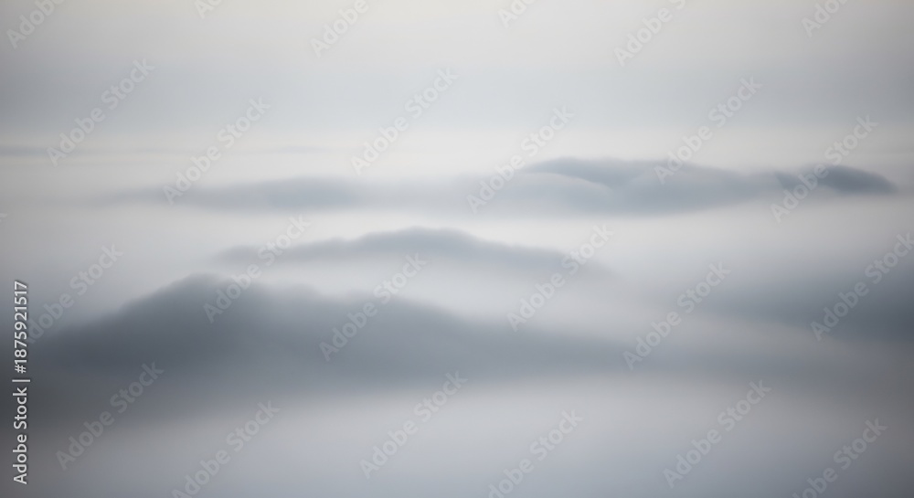Fototapeta premium Serene Mountainscape - A Misty Mornings Gentle Embrace, Tranquil Peaks in the Distance.