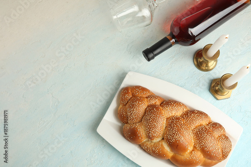Foto Traditional challah bread with wine and burning candles on light grunge background