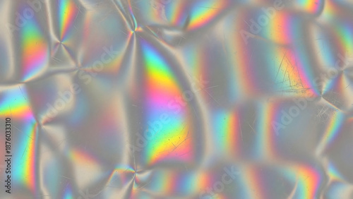 Iridescent foil surface with rainbow reflections abstract and textured background.