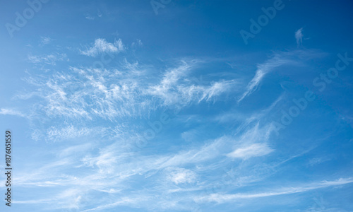 wide-angle landscape shot of a bright azure sky filled with delicate, streaky white clouds. This serene and airy image is perfect for nature backgrounds, weather themes, and peaceful designs.