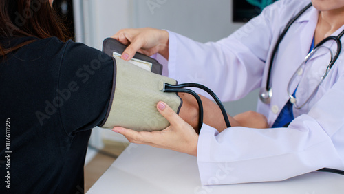 Photos Close up asian female doctor sitting at desk using measure blood pressure checking patient in medical clinic hospital presenting results examination preventive care healthcare services consultation