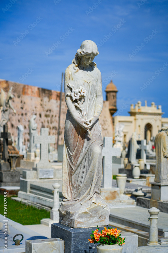 Obraz premium Elegant marble statue of a woman holding flowers in the Santa Maria Magdalena de Pazzis Cemetery in Old San Juan, Puerto Rico