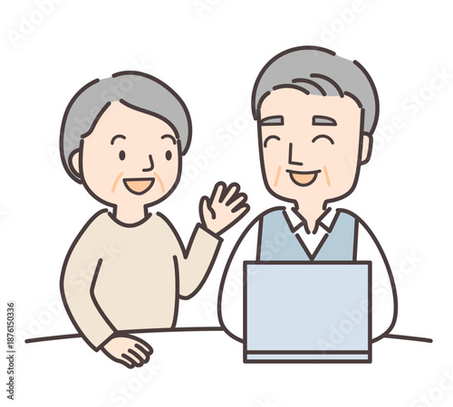 パソコンの前で会話するシニア夫婦