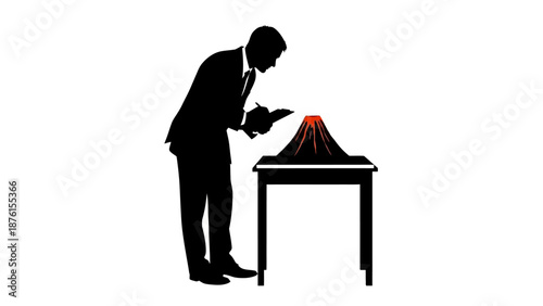 Man in suit examining a volcano model on a table with intense focus