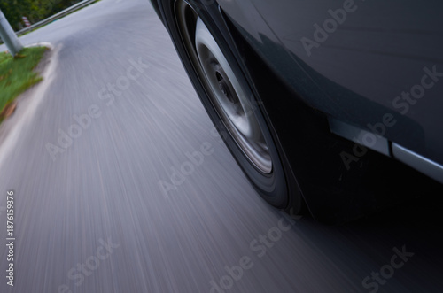 Close up of car wheel on road with motion blur, speed driving concept