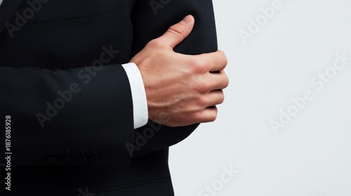 Man in Dark Suit Arm Crossing Gesture on Light Background