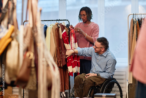 Foto Middle aged Caucasian man with disability sitting in wheelchair browsing second