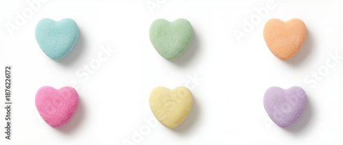 Six pastel colored heart shaped conversation candies scattered evenly across a bright white surface in two rows candy sweet valentine love sugar confection pink mint orange purple yellow