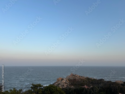 Foto A vast expanse of sea, with rocks in the foreground.