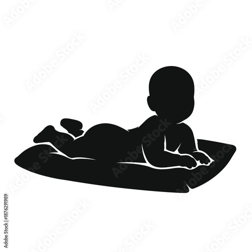 Silhouette of baby lying on stomach on mat