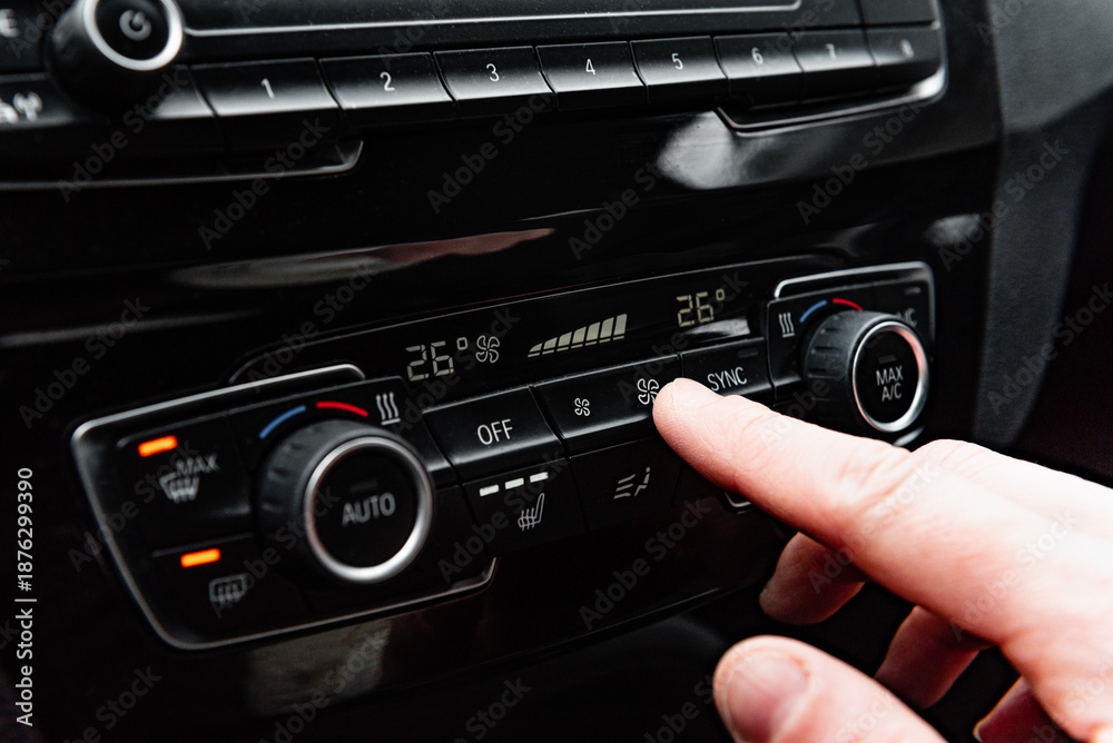 Fototapeta premium Hand pressing the button for interior heating and heated seats in the car in winter.