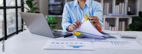 Businesswoman hands working in Stacks of paper files for searching and checking unfinished document achieves on folders papers at busy work desk office

