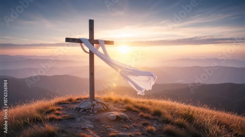 Wooden cross with white cloth blowing in the wind on a mountain peak at sunrise. Christian symbol of Easter and resurrection