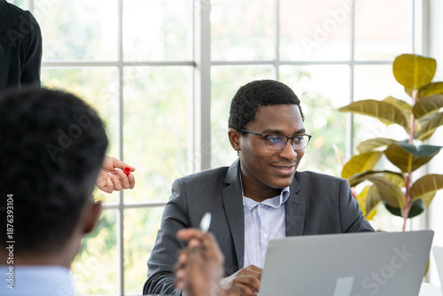 black business man smiling while working at laptop
