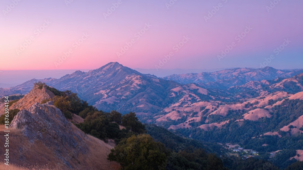 Obraz premium Majestic mountain range bathed in the soft hues of a serene sunset sky, a breathtaking natural vista.
