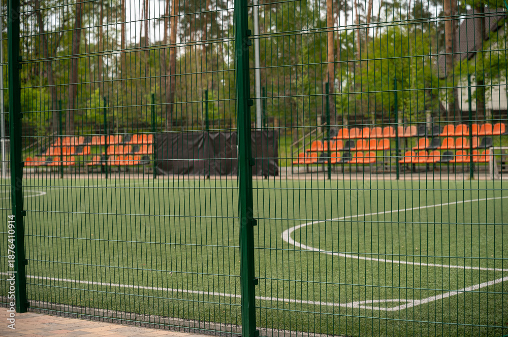 Fototapeta premium football field with white lines on the grass. With orange stands.