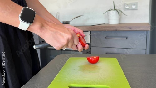 Close up of woman hands peeling tomato skin with knife during food preparation in home kitchen. Ingredient processing step, homemade cooking routine and everyday meal preparation at home