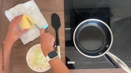Top view of woman hands adding butter to pan and frying onion in home kitchen. Homemade cooking process, ingredient preparation step and everyday meal making routine at home.