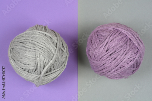 Top view of a grey and a purple ball of wool yarn placed on a matching split purple and grey background
