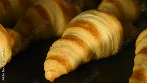 Timelapse video of homemade croissants baking inside an oven, gradually rising and turning golden brown. The footage captures the transformation of raw dough into flaky, freshly baked pastries