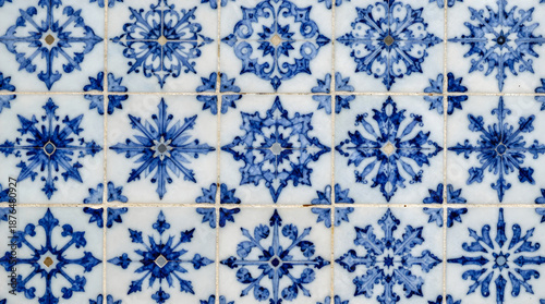 A close-up view of a wall featuring a mosaic pattern made of blue and white tiles with floral designs