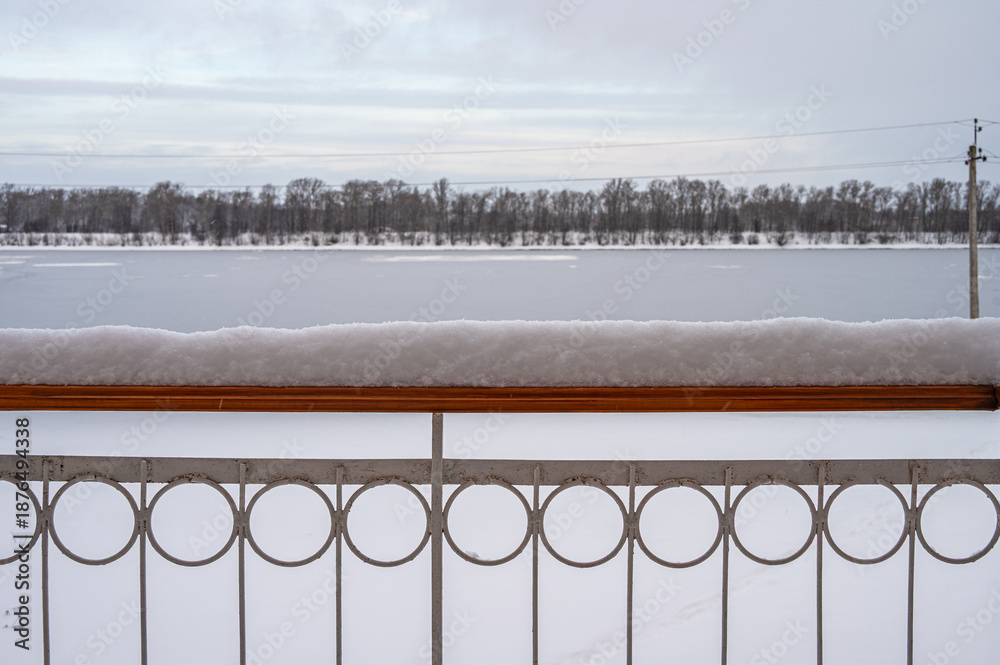 Naklejka premium Snow on the balcony railing during heavy snowfall.