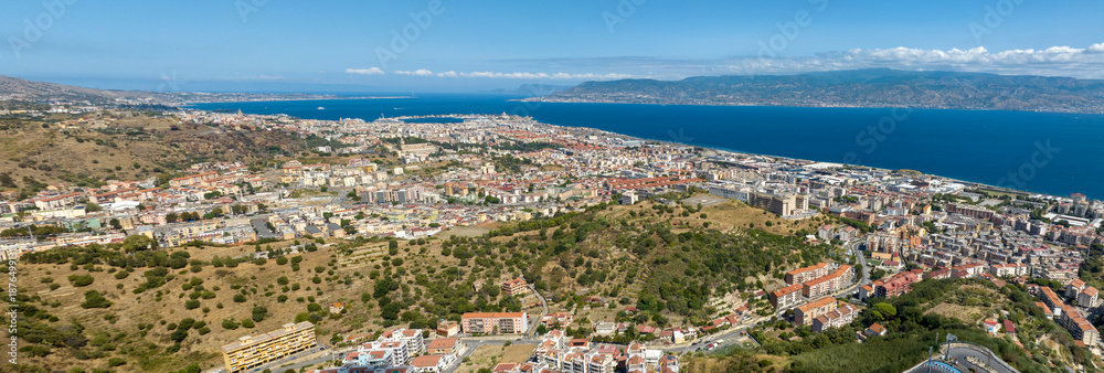 Naklejka premium Aerial panorama of the Strait of Messina. It is a narrow strait between the eastern tip of Sicily and the western tip of Calabria, in Southern Italy. It connects the Tyrrhenian Sea with the Ionian Sea
