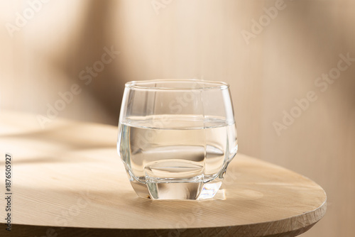 A clear glass of clean drinking water placed on a wooden table in soft natural light, symbolizing hydration, health, simplicity, and the benefits of drinking water for the body.