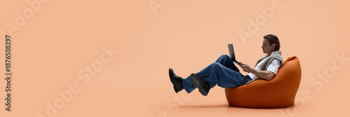 Man working on laptop while levitating on bean bag chair. Concept of startup culture, creative freelance work, content production, flexible workspace and long focused work cycles. Banner