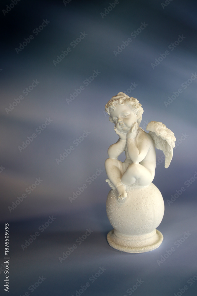 Fototapeta premium Angel sculpture on blue background